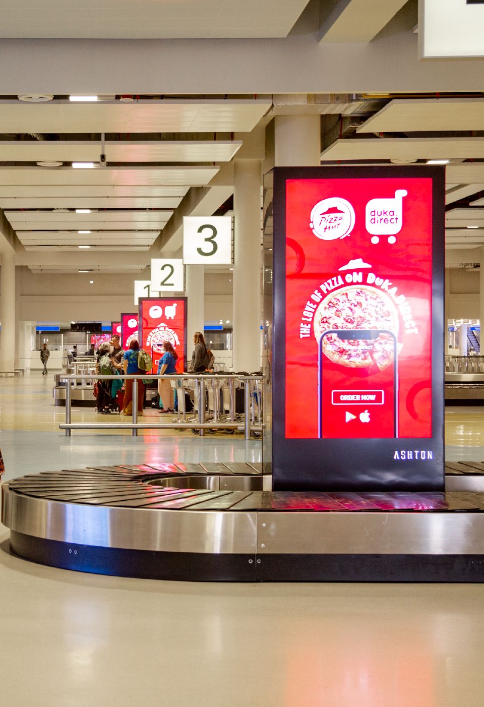 A digital totem screen in the airport baggage hall