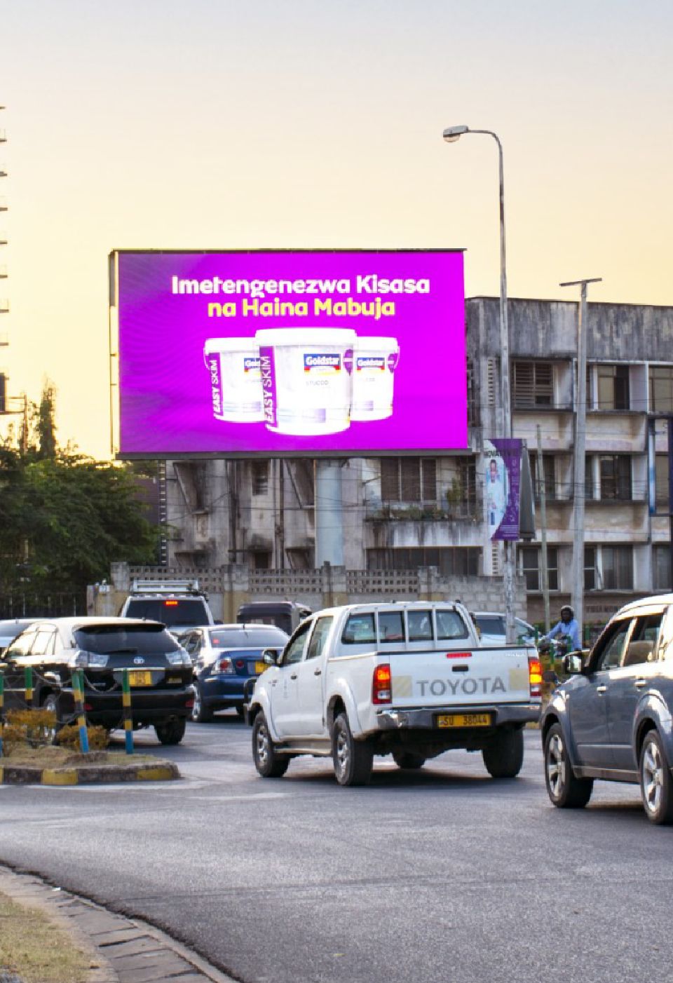 A digital LED screen on a main road at dusk